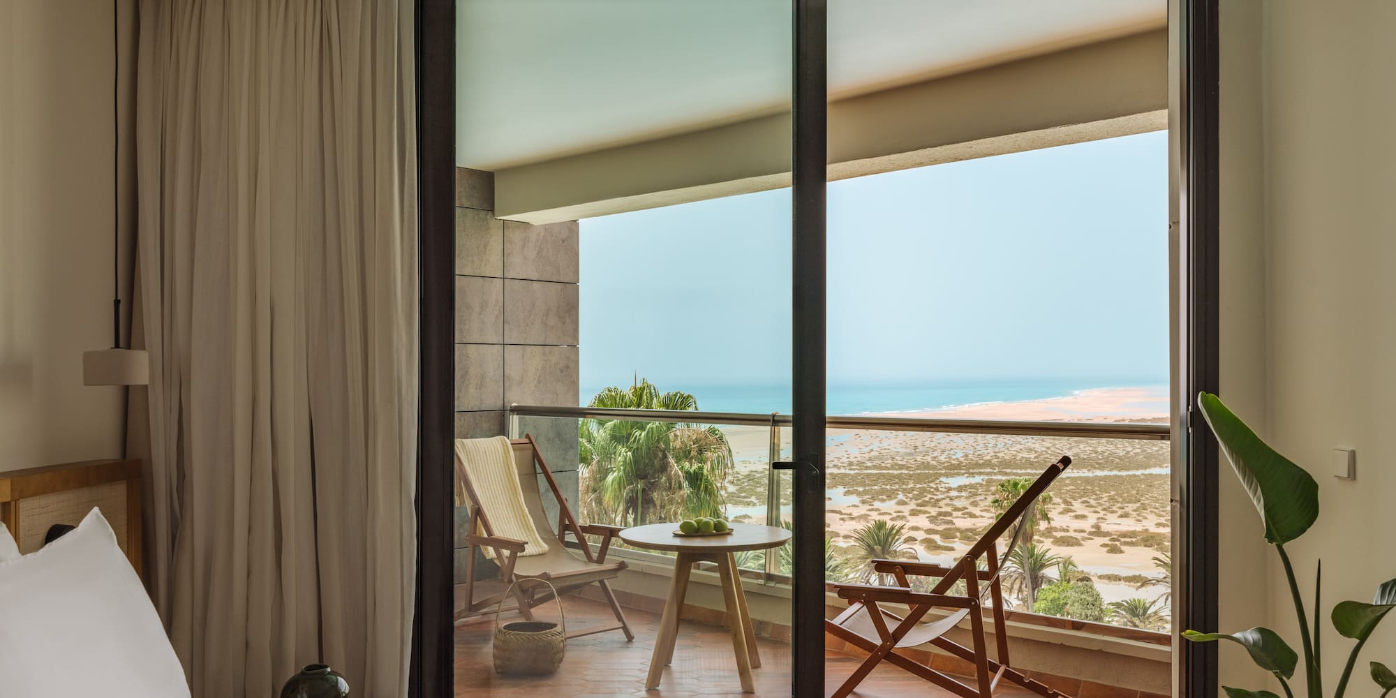 a bedroom with a view of the ocean from the balcony