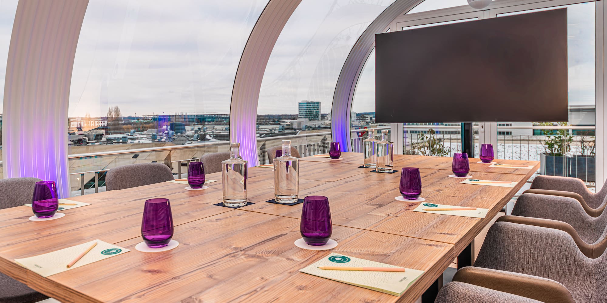 a table with purple glasses and a television on it