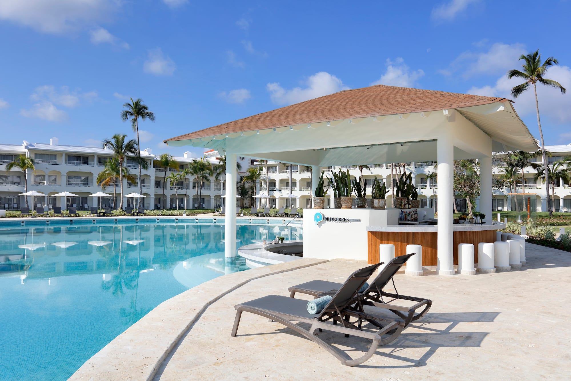 a pool with lounge chairs and a bar