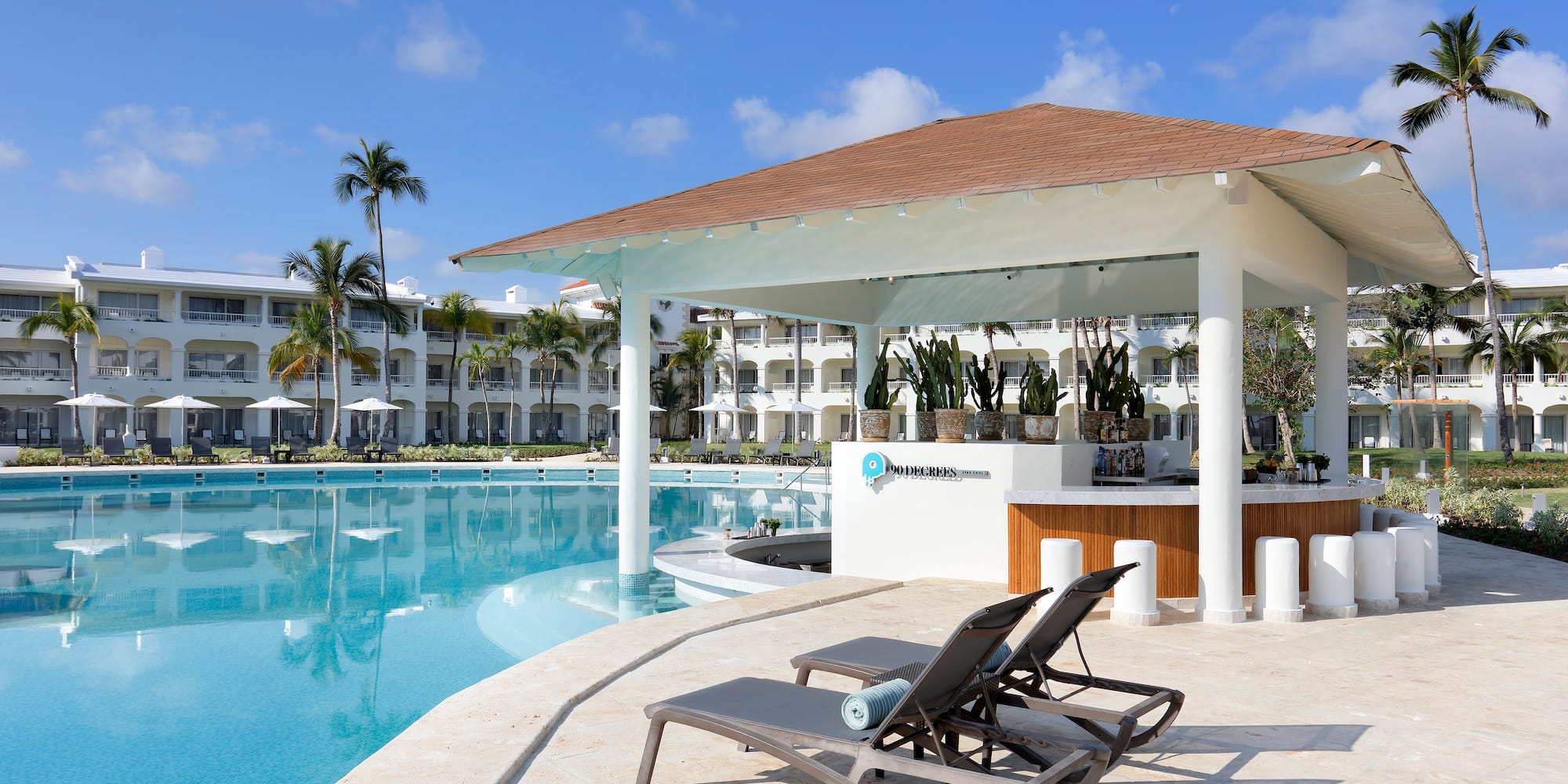 a pool with lounge chairs and a bar