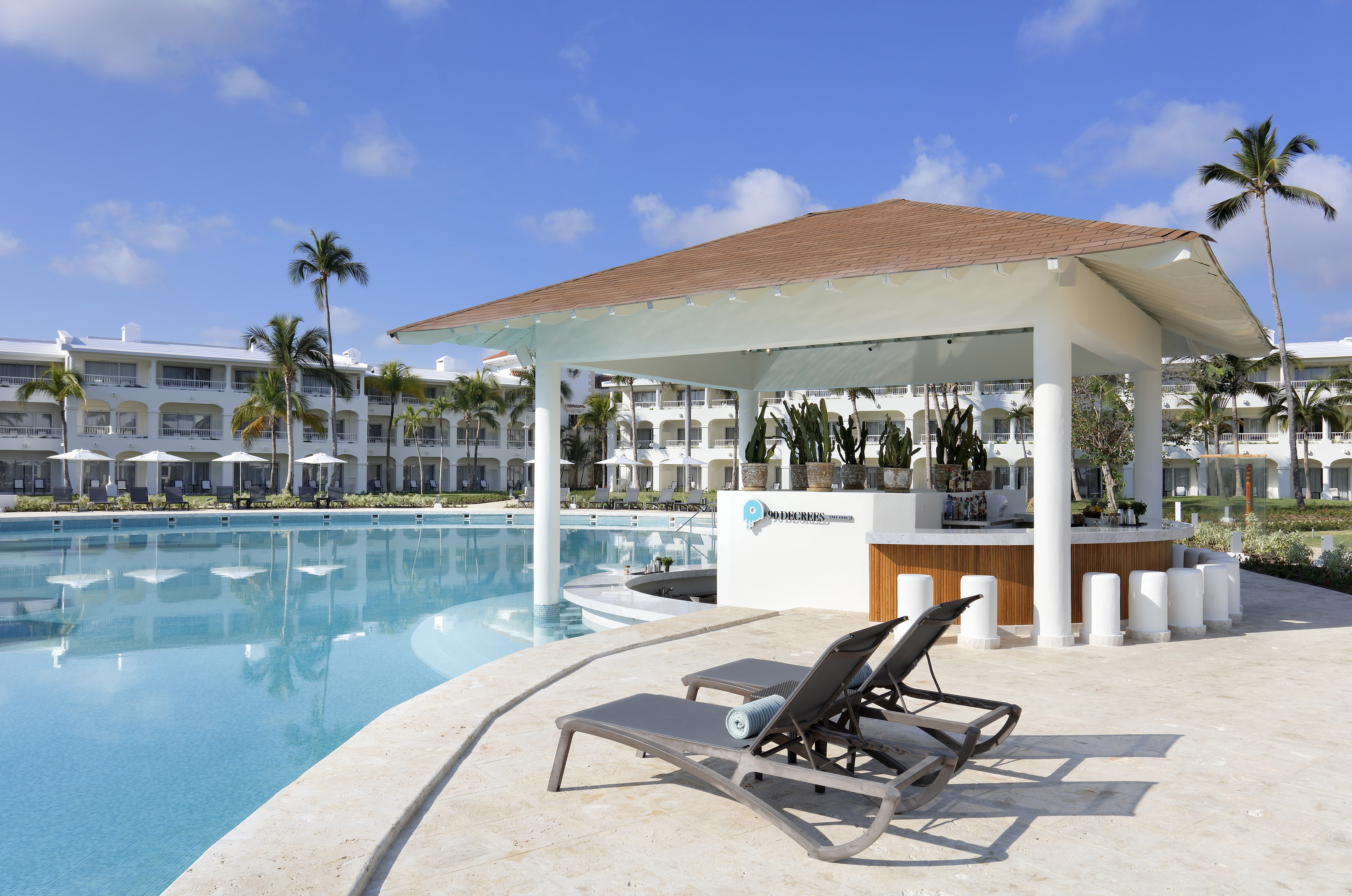 a pool with lounge chairs and a bar