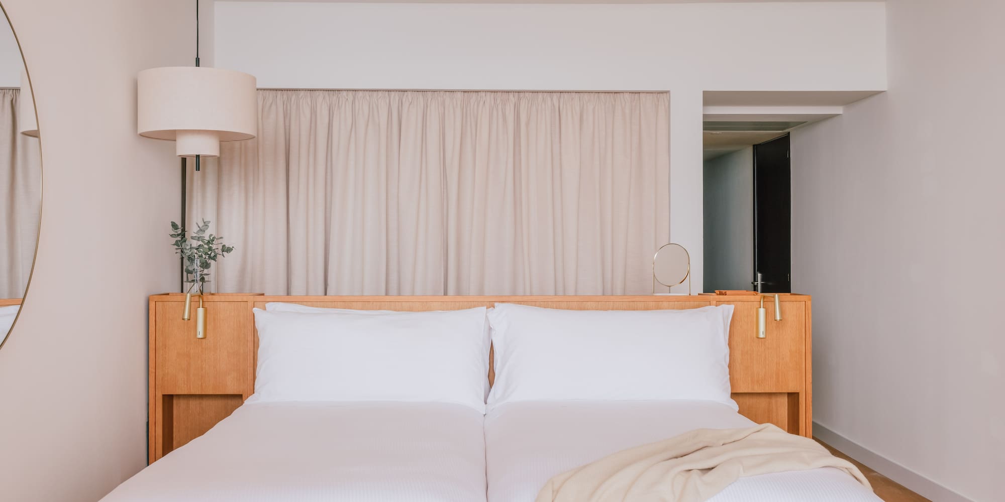 a bed with white sheets and a lamp