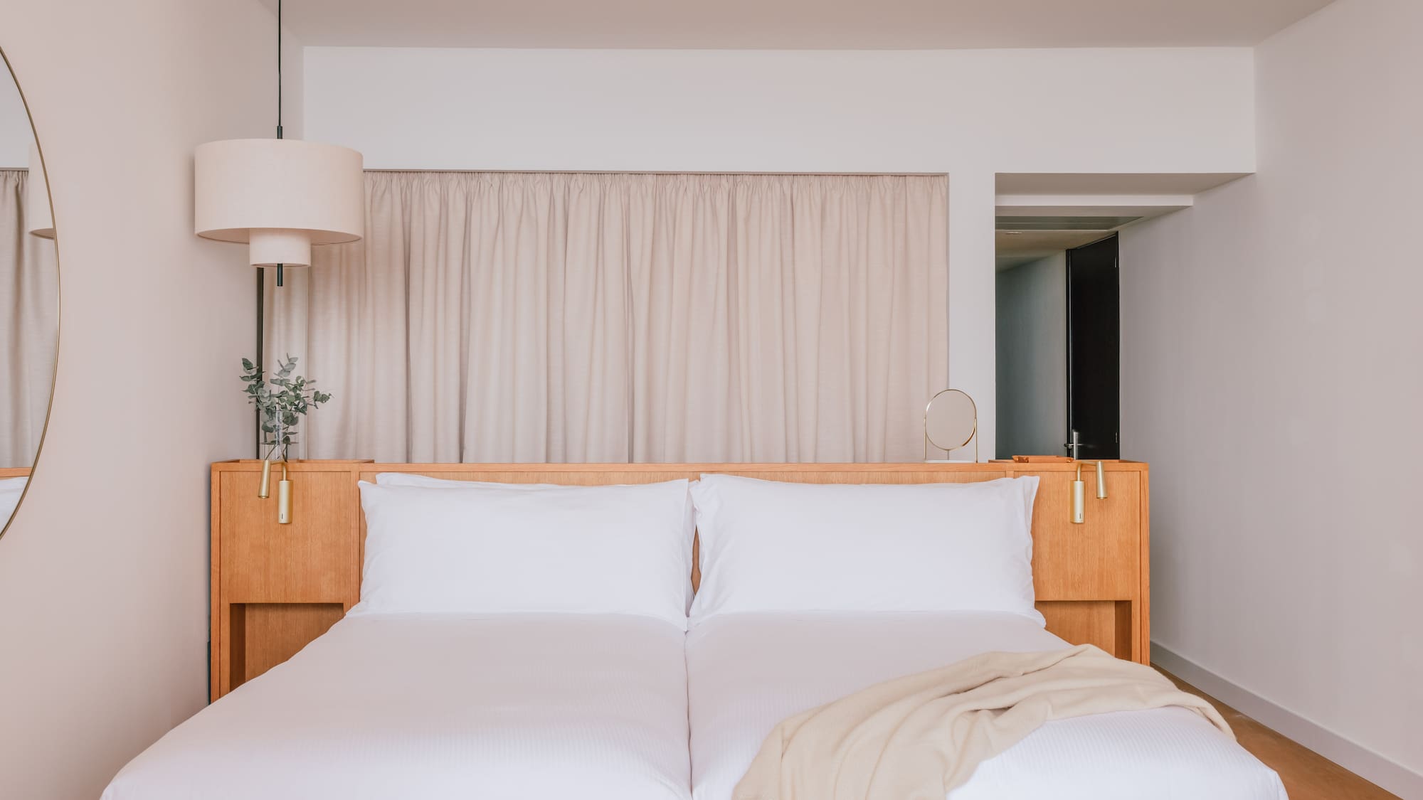 a bed with white sheets and a lamp