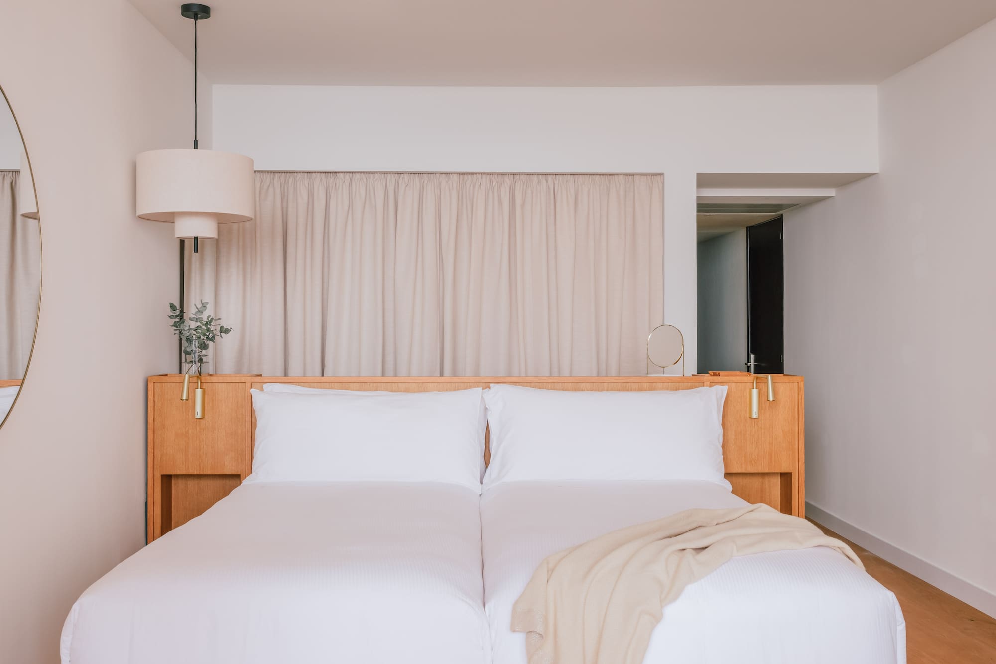 a bed with white sheets and a lamp