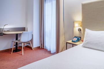 a room with a bed and a desk and chair