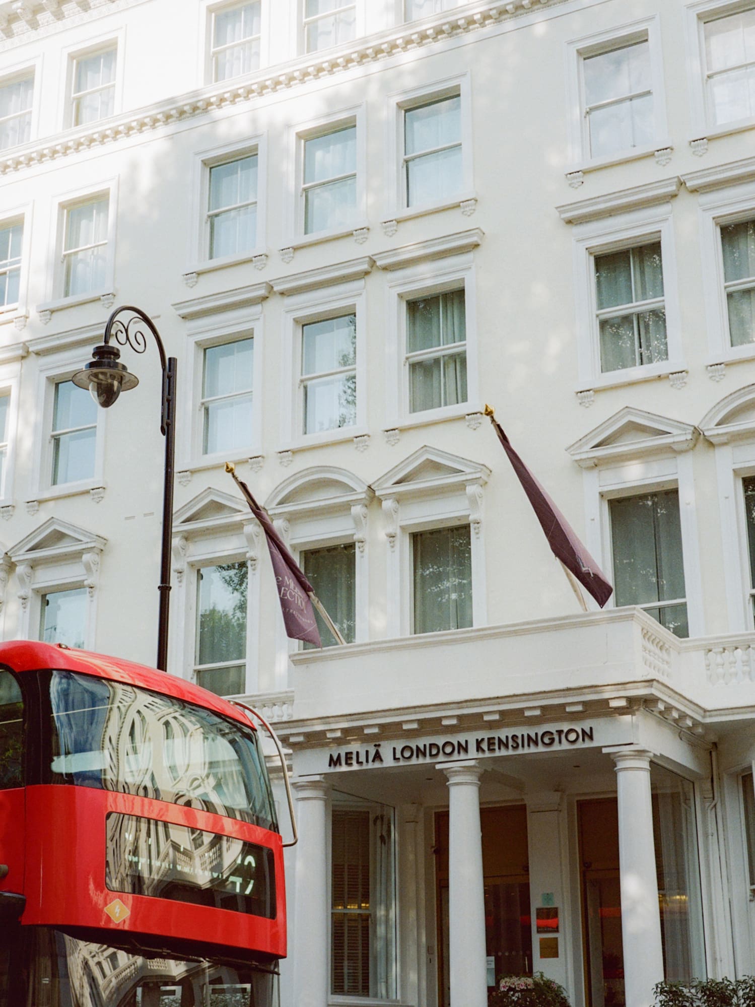 Red double-decker bus in front of Melia London Kensington hotel.