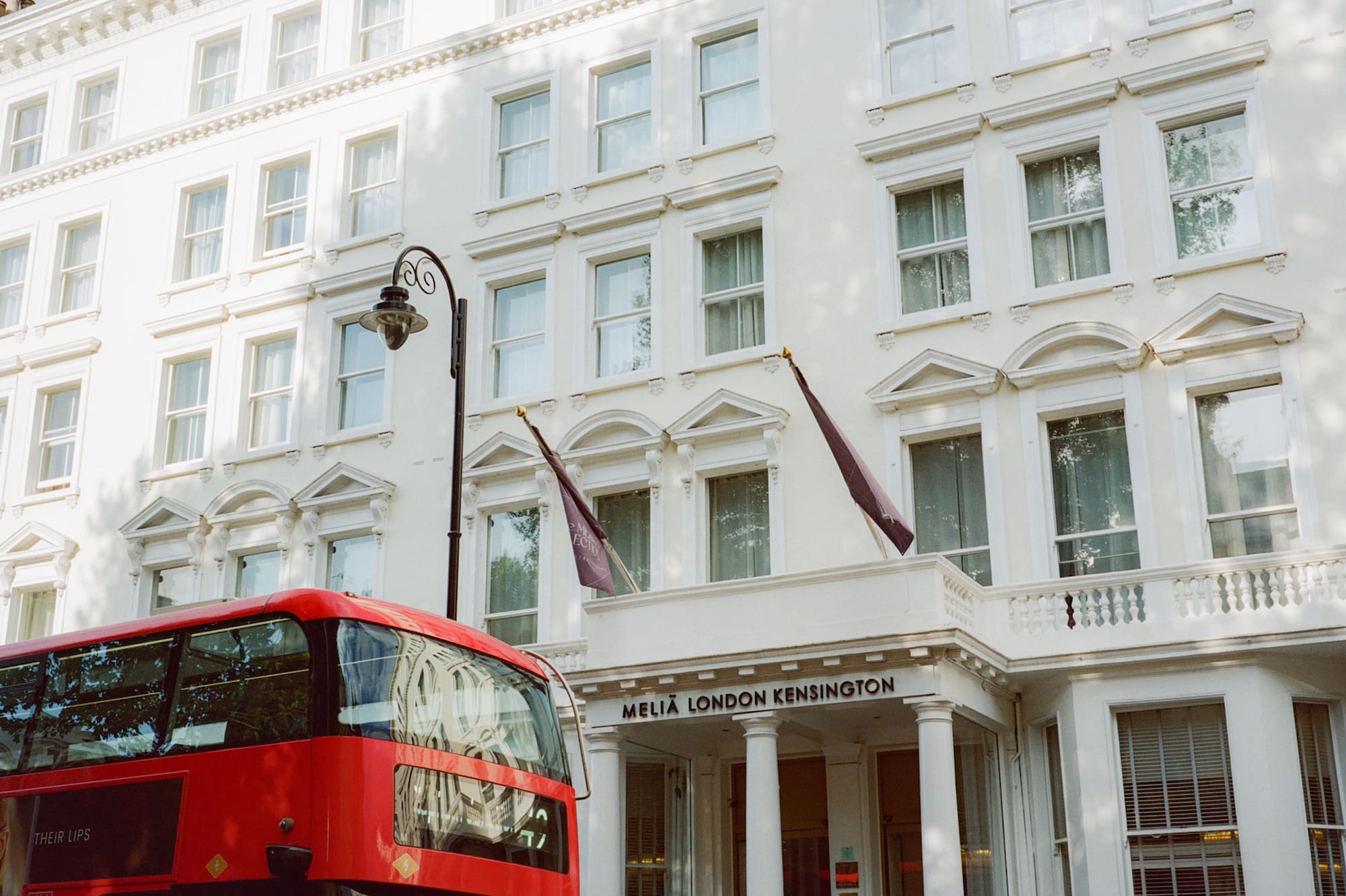 Hotel Meliá London Kensington blanco y autobús rojo de dos pisos.