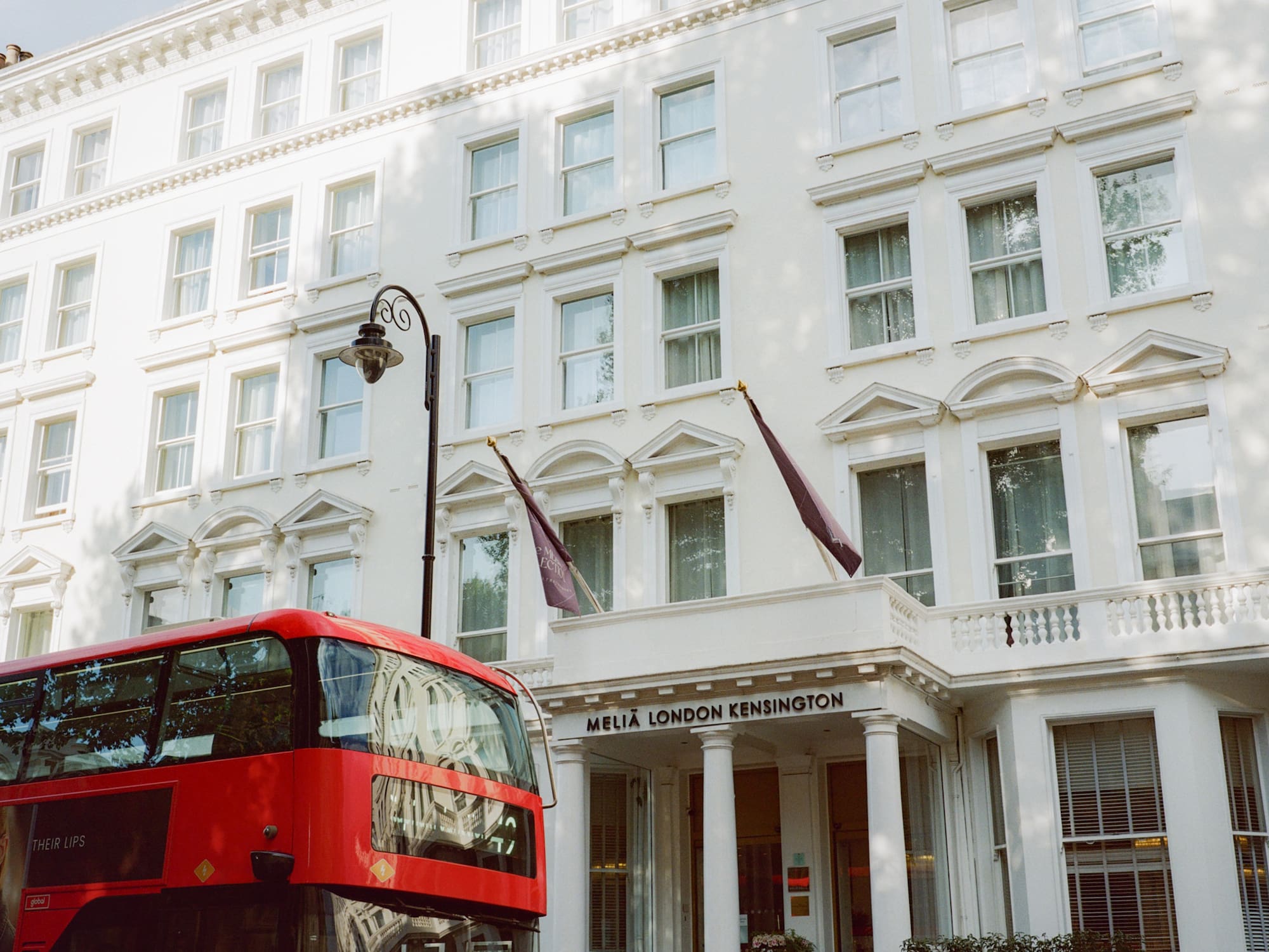 a double decker bus in front of a white building
