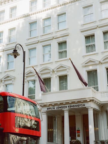 a double decker bus in front of a white building