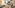 Modern hotel guest room with bed, sofa, TV, and open wardrobe.