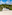 Aerial view of luxury beach resort with white cabanas, palm trees, and hotel buildings.