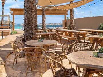 tables and chairs outside on a beach