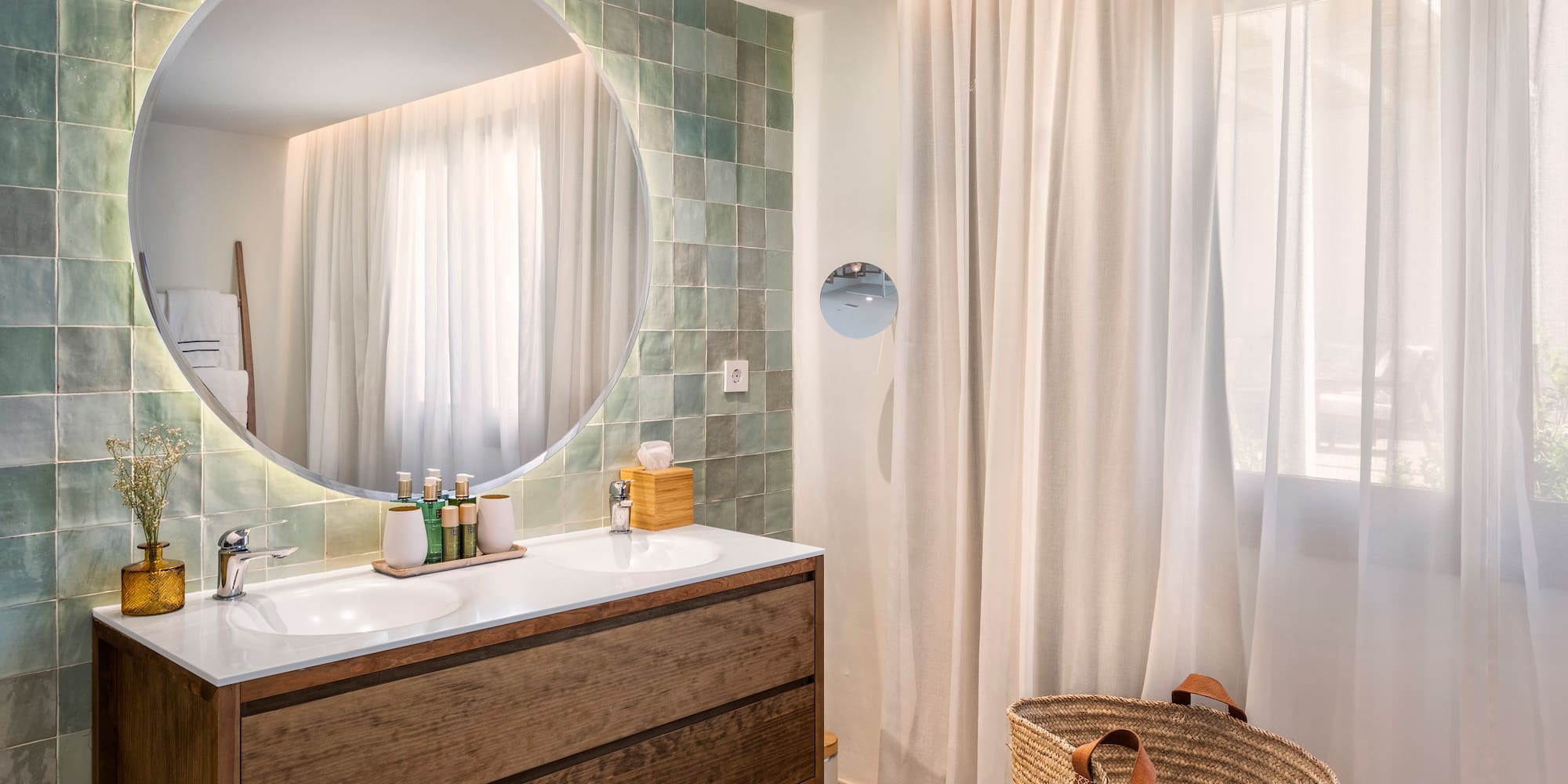 a bathroom with a round mirror and a basket