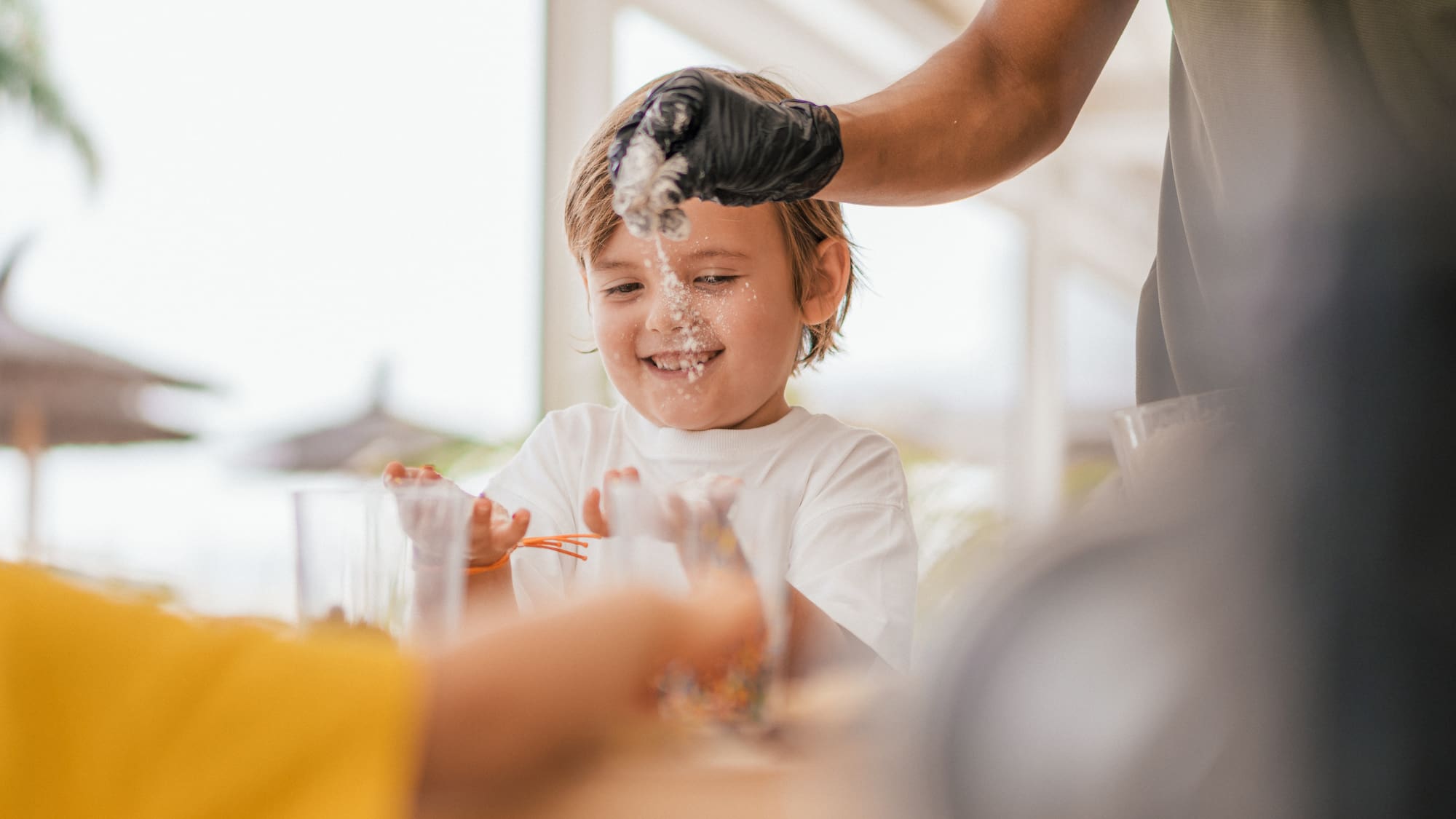 a person pouring liquid onto a child's face