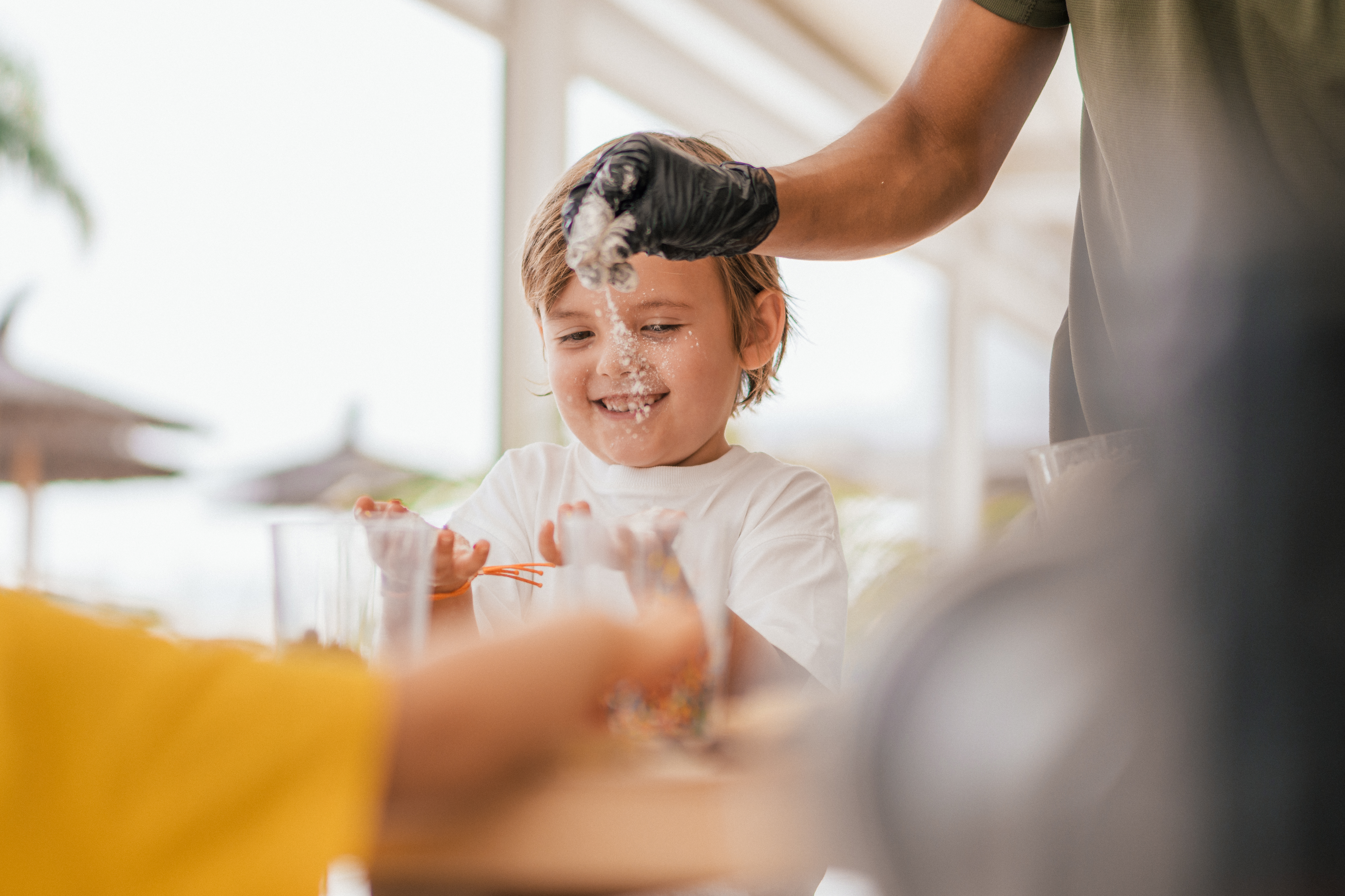 a person pouring liquid onto a child's face