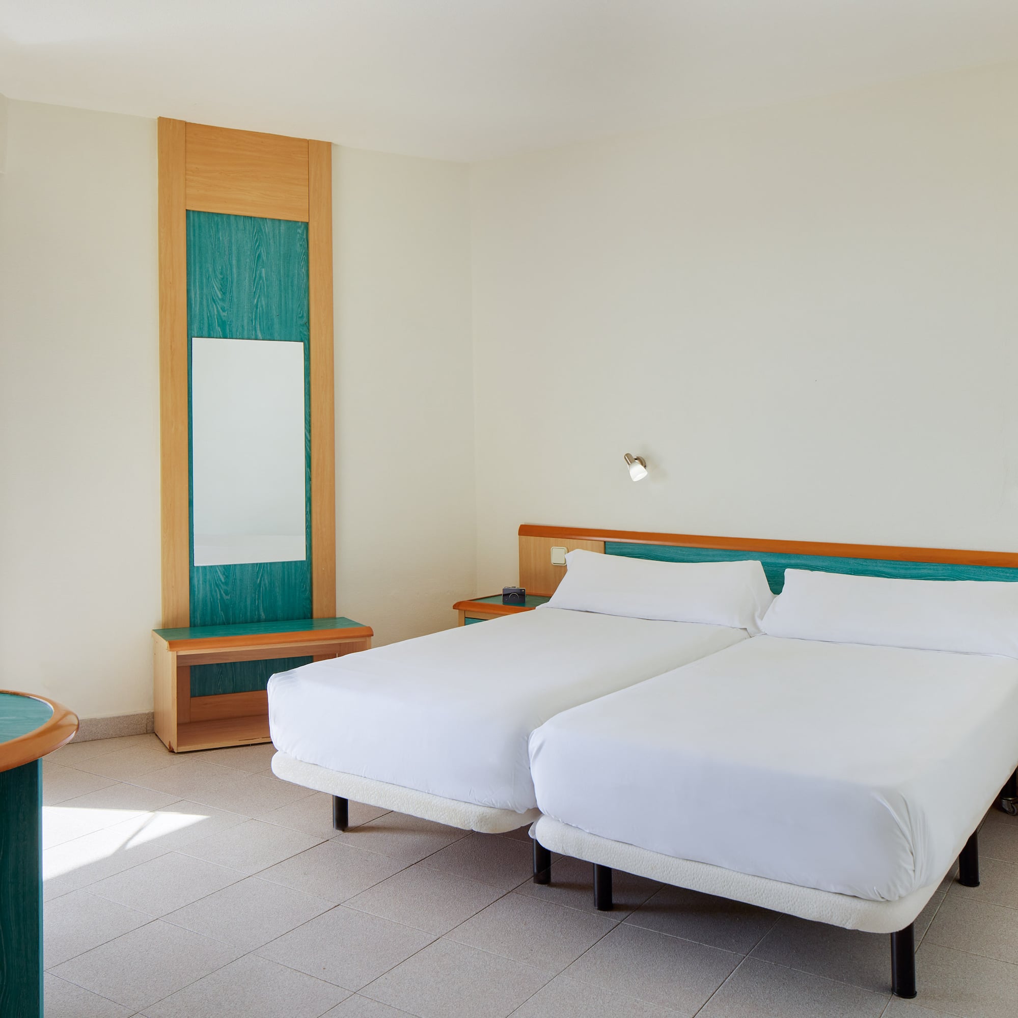 a room with two beds and a mirror