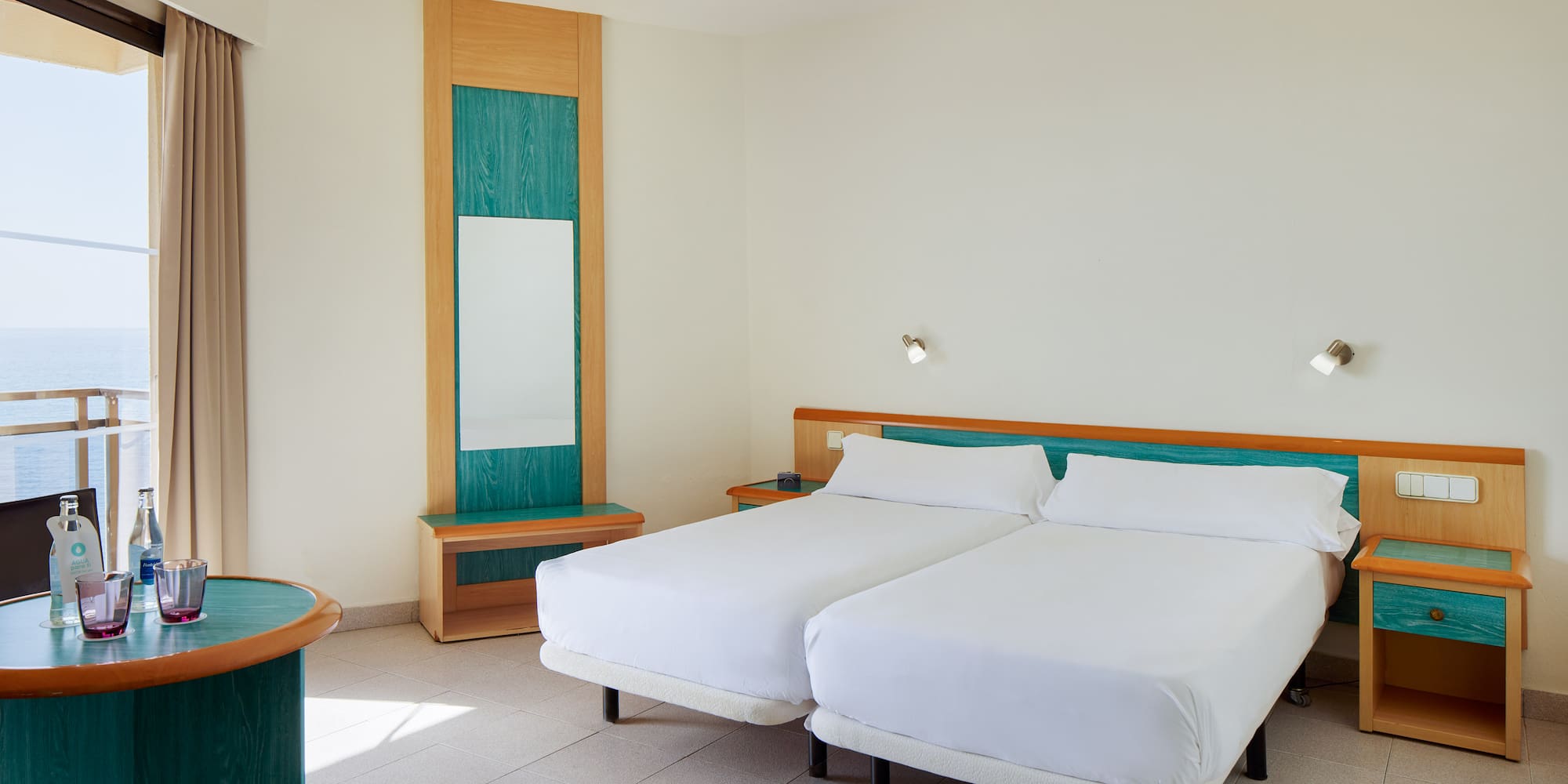 a room with two beds and a mirror