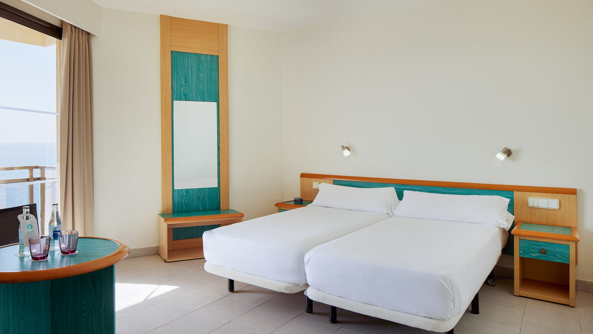 a room with two beds and a mirror