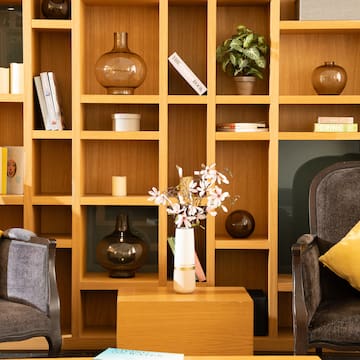 a shelf with books and vases on it