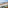 Balcony ocean view with green chairs, beach, marina, and coastal town.