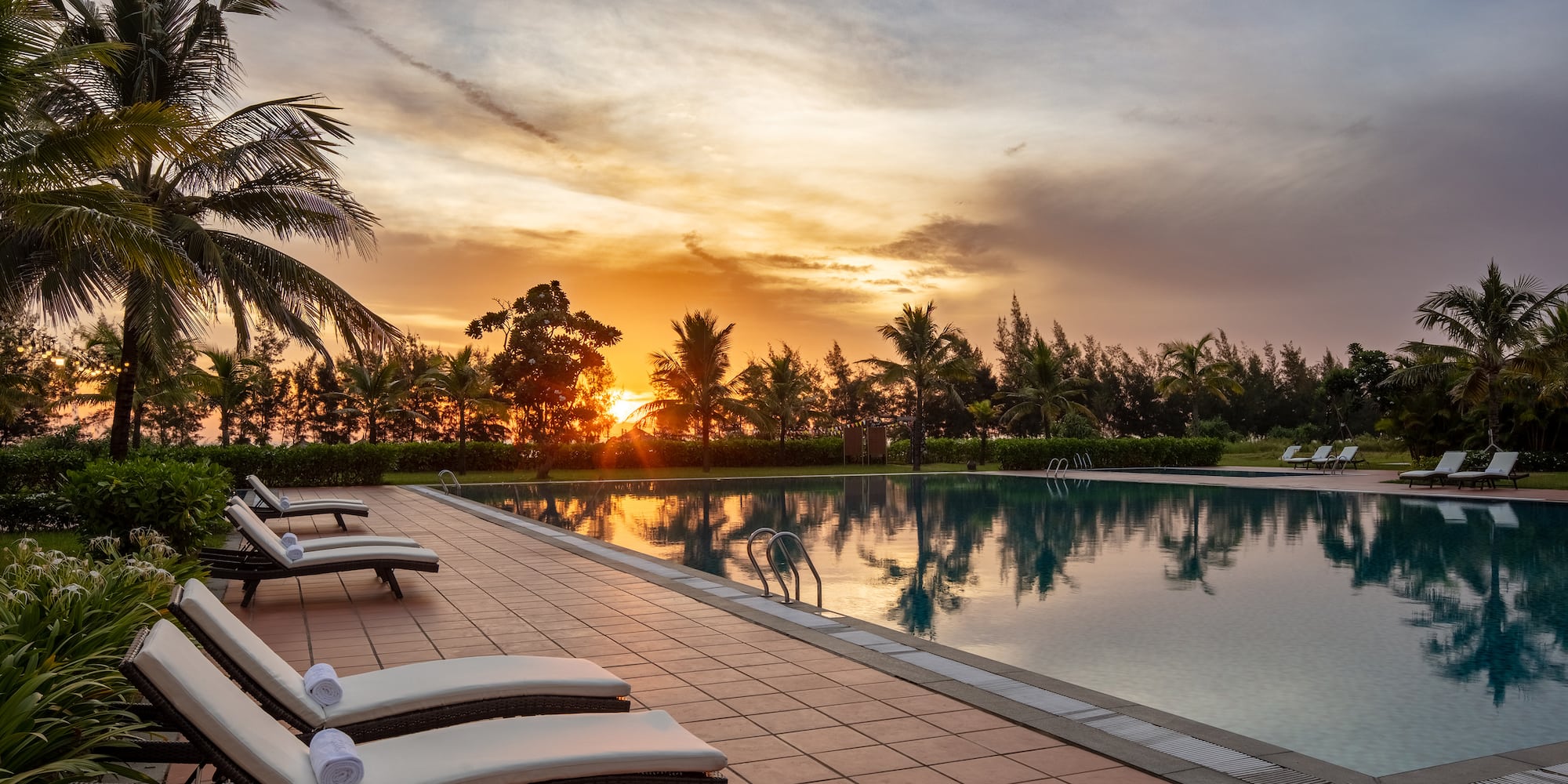 a pool with lounge chairs and palm trees