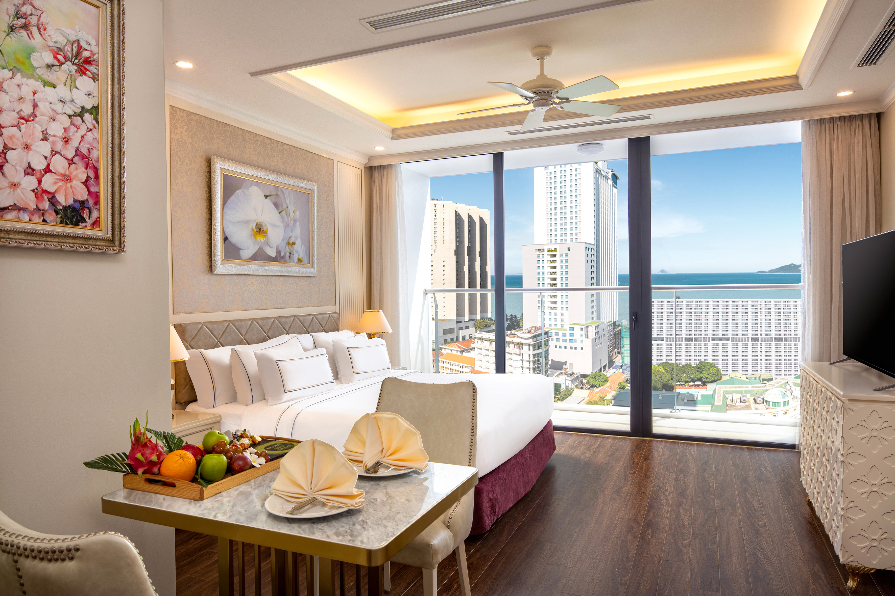 a room with a bed and a table with fruit on it