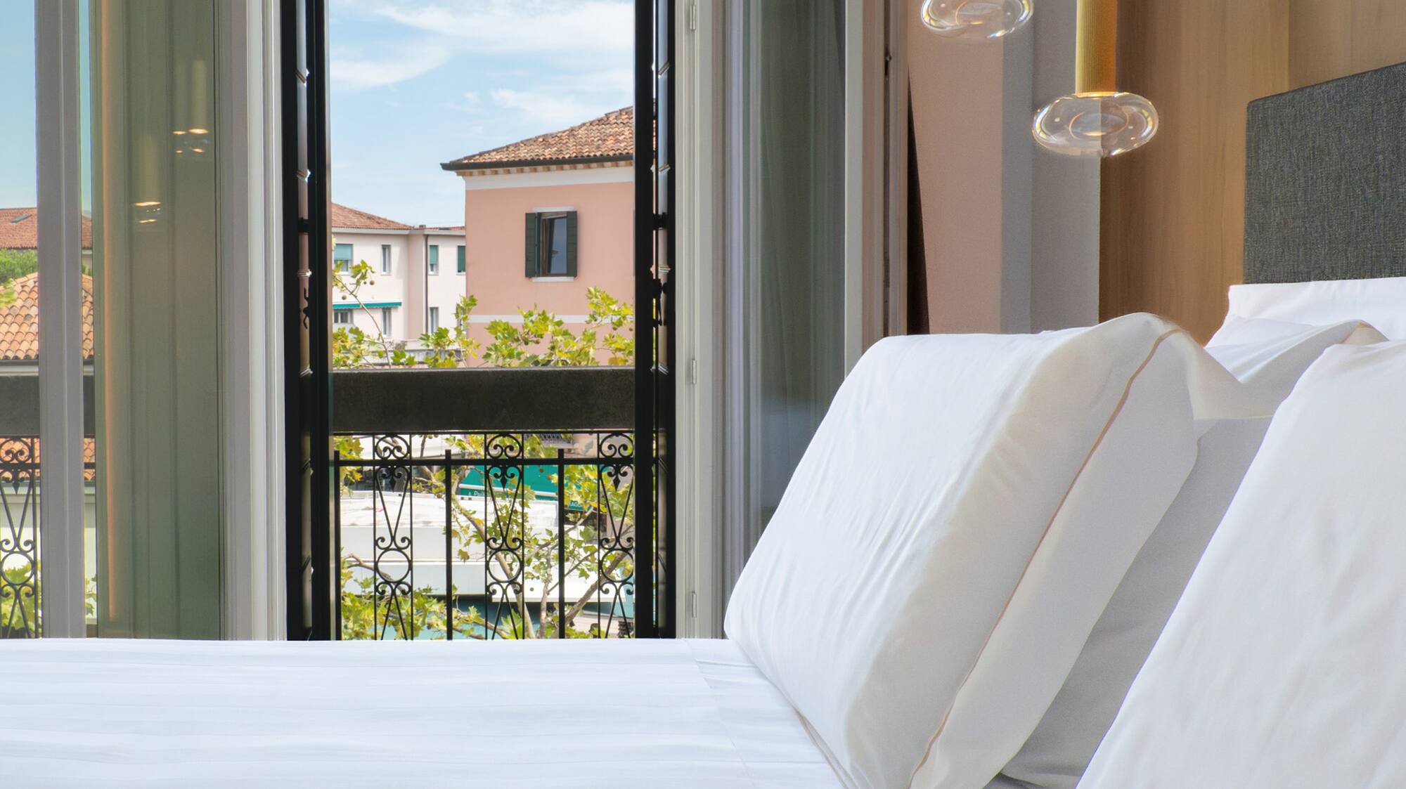 a bed with white sheets and pillows