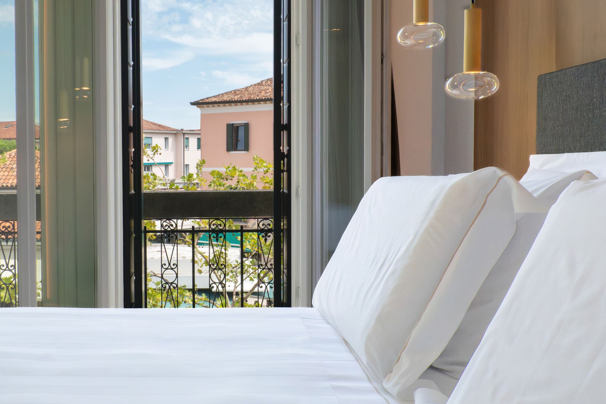 a bed with white sheets and pillows