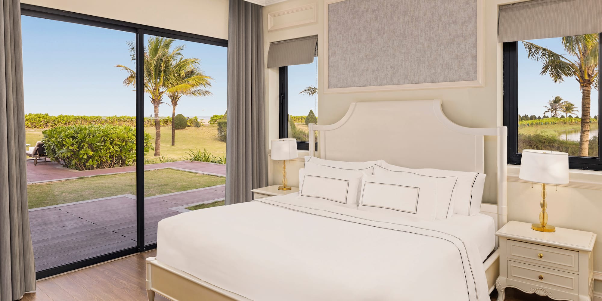 a bedroom with a large bed and glass doors