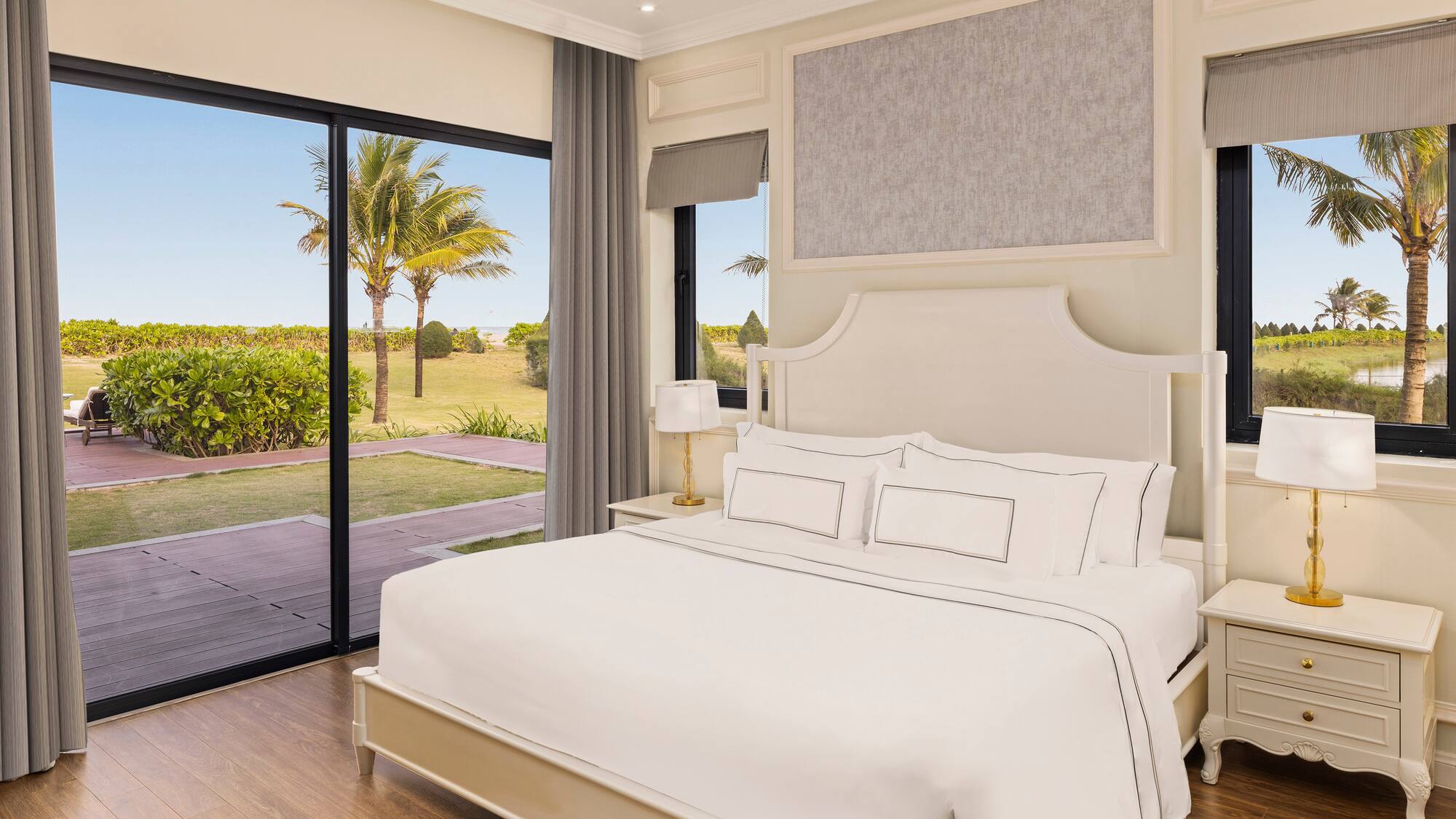 a bedroom with a large bed and glass doors