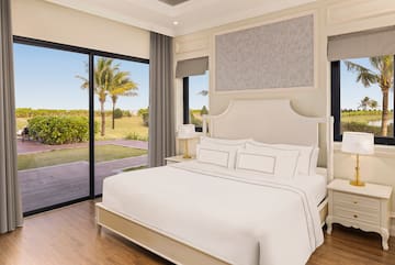 a bedroom with a large bed and glass doors