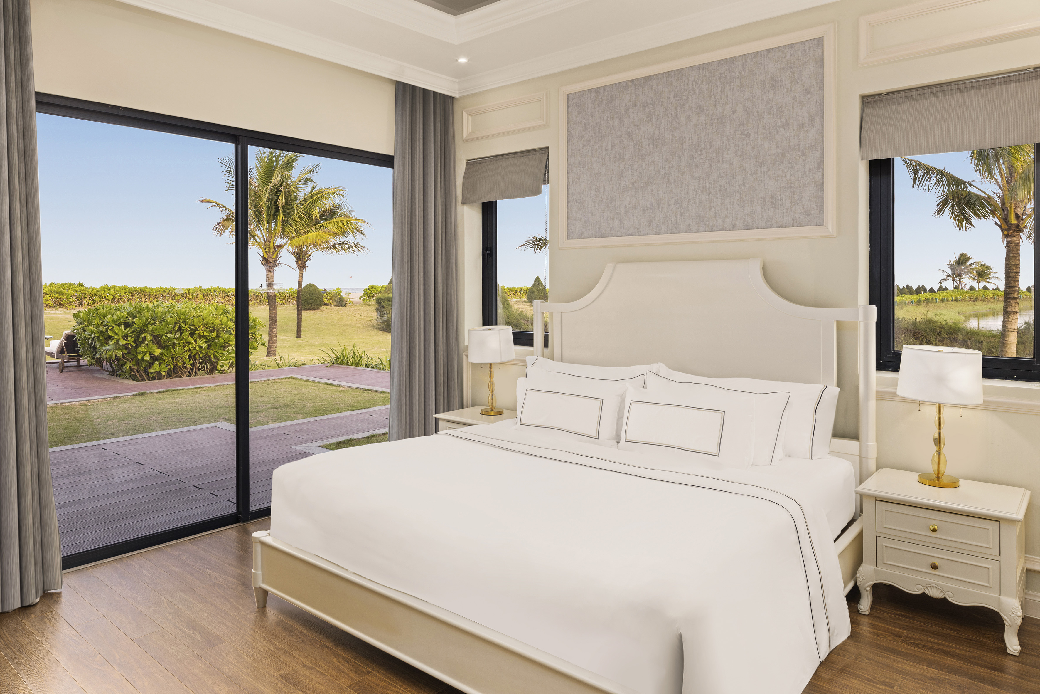 a bedroom with a large bed and glass doors