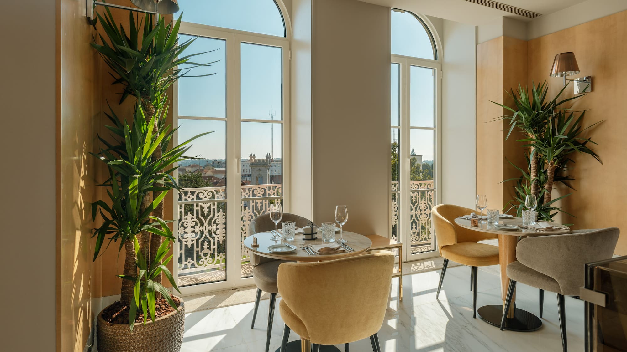 a room with tables and chairs and plants
