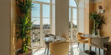 a room with tables and chairs and plants