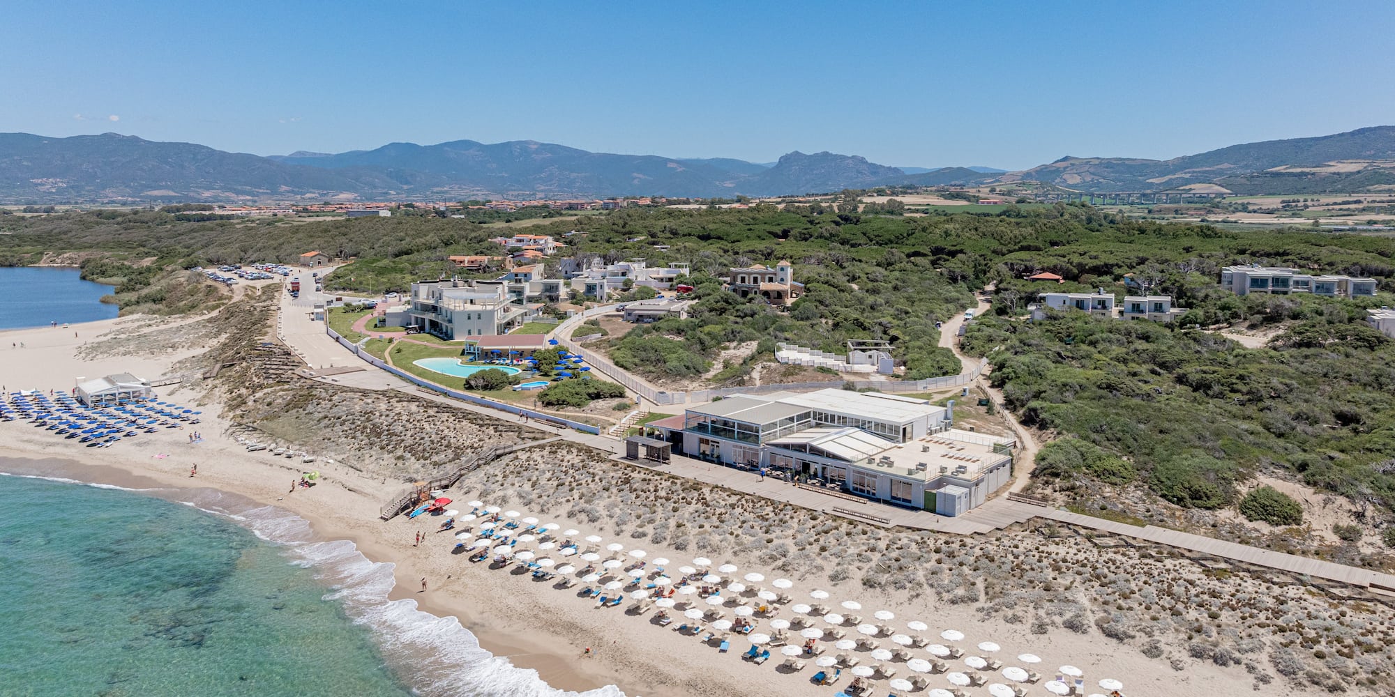 a beach with a building and umbrellas