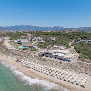 a beach with a building and umbrellas