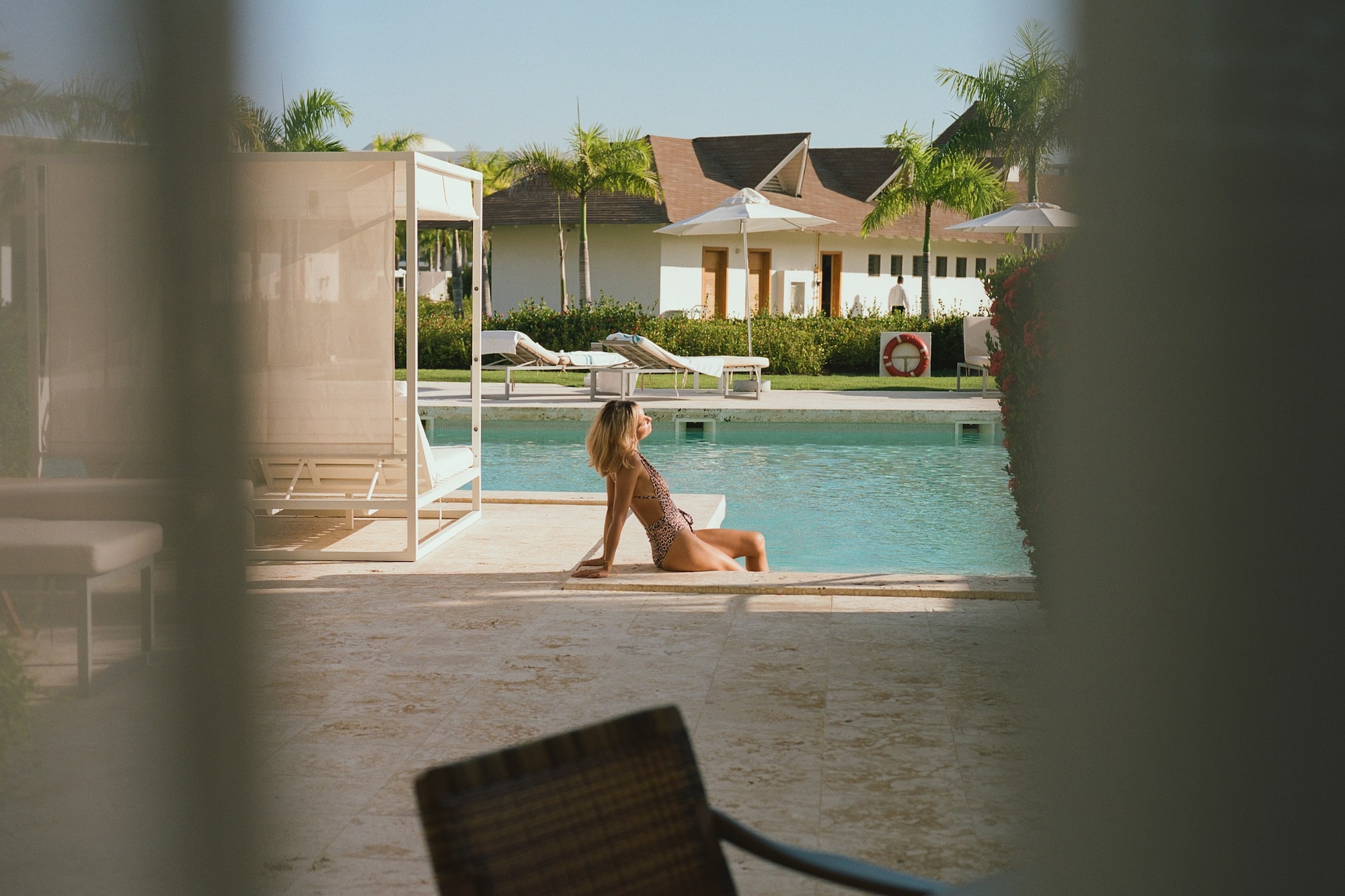 a woman sitting in a swimsuit by a pool