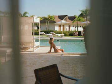 a woman sitting in a swimsuit by a pool