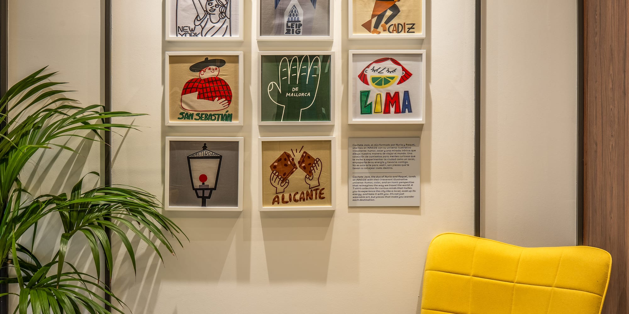 Modern hotel lounge with vibrant yellow chair and framed illustrative travel art.