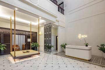 a lobby with a white reception desk and a white and black tiled floor