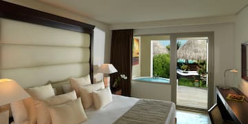 a bed with a glass door leading to a pool