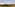 Hot air balloon flying over a Tuscan vineyard with hills under a cloudy sky.