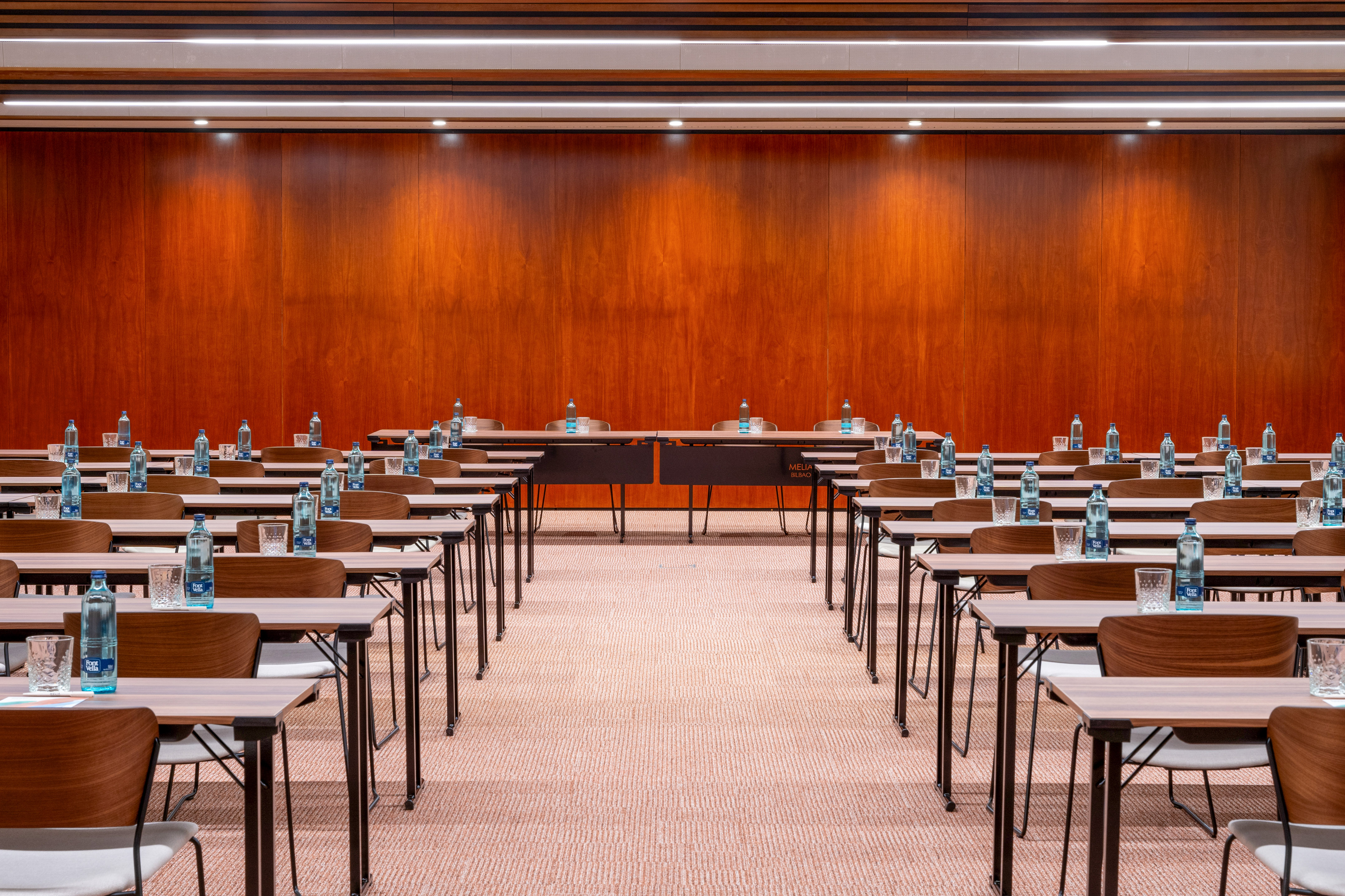 Conference room with rows of tables, chairs, and water bottles. Meliá Bilbao.