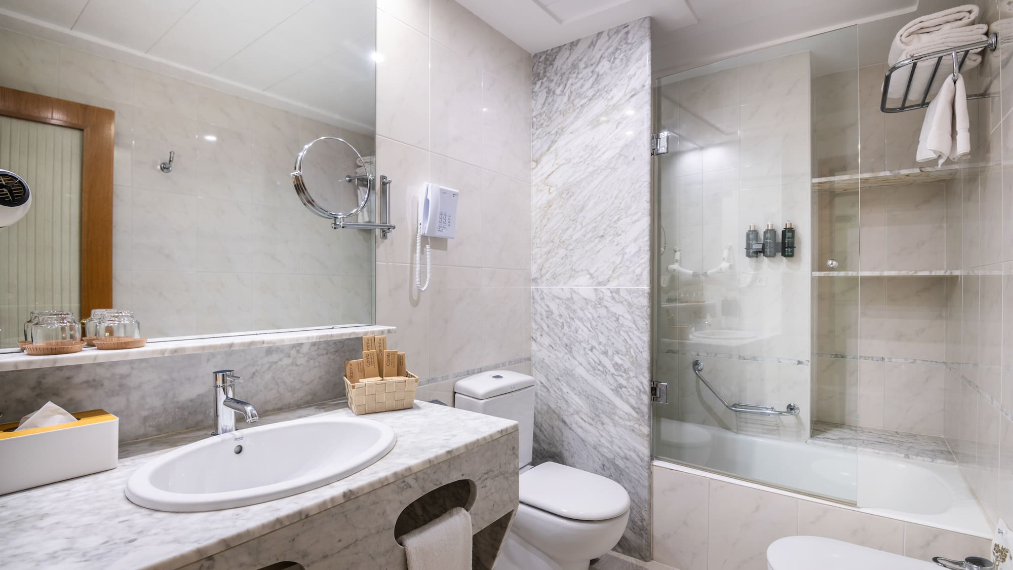a bathroom with marble walls and a shower