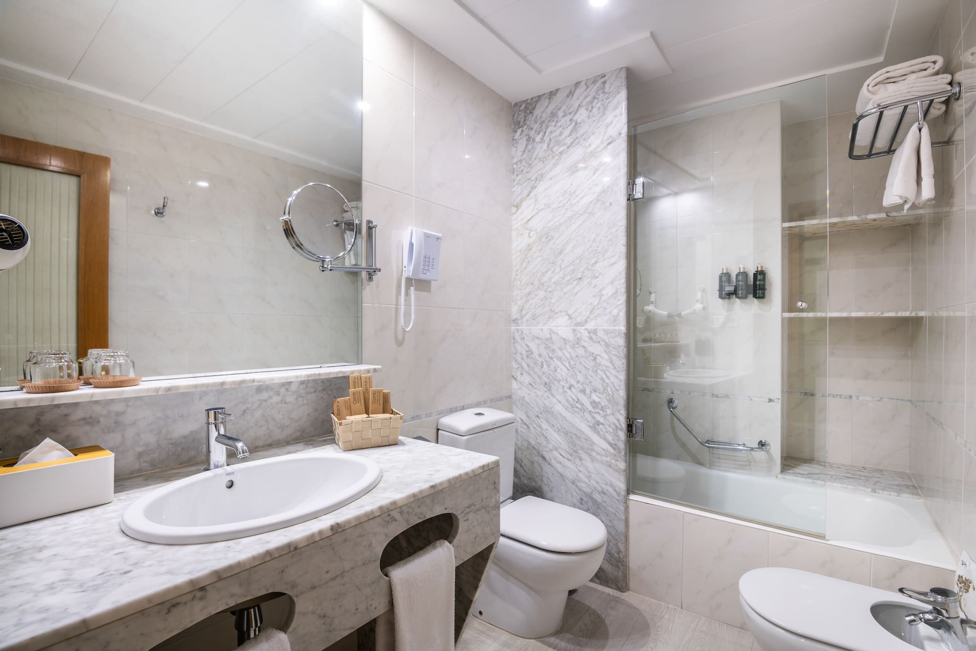a bathroom with marble walls and a shower