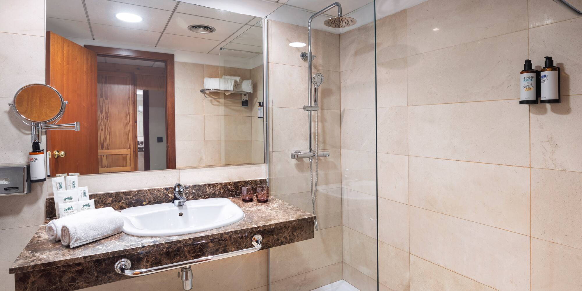 a bathroom with a glass shower and sink