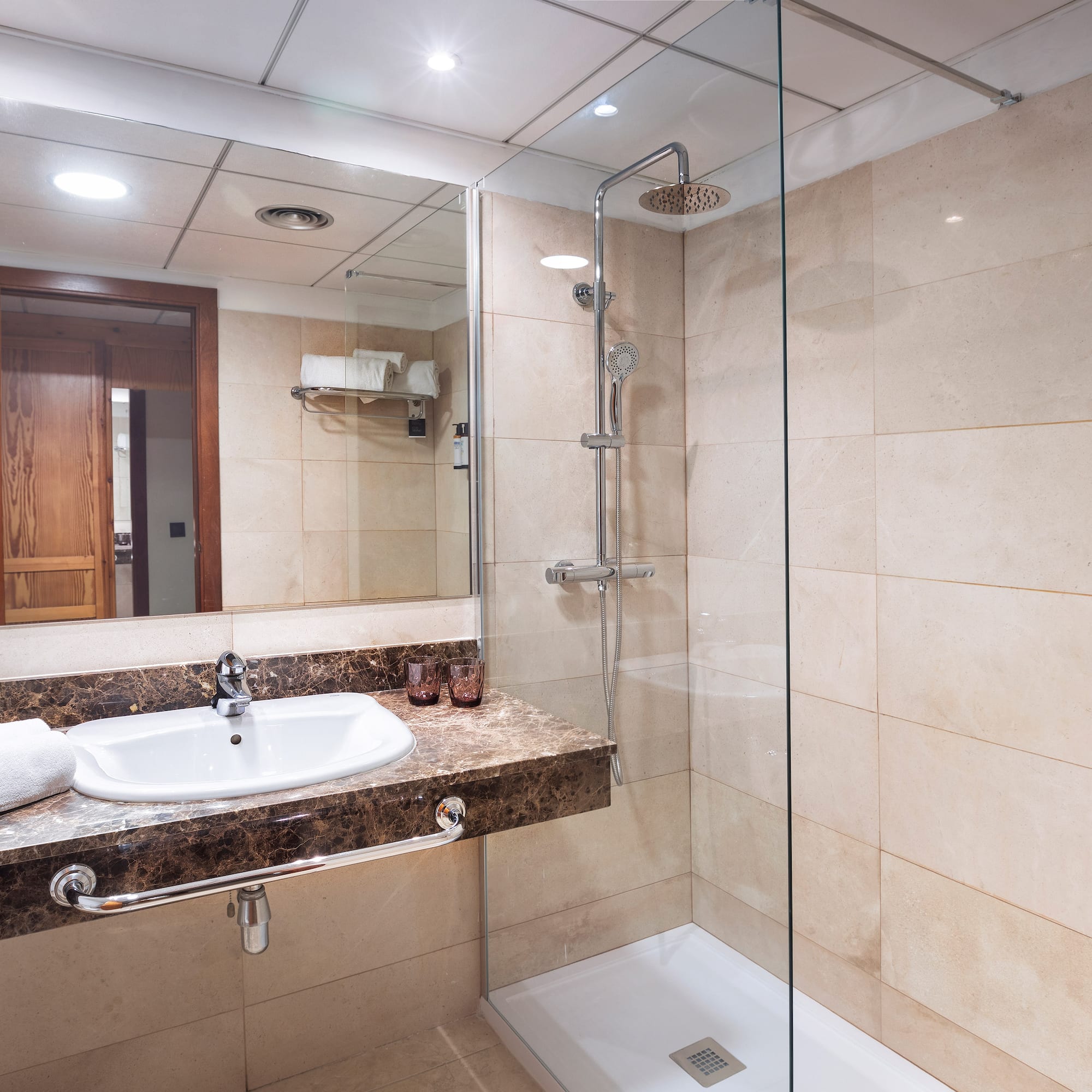 a bathroom with a glass shower and sink