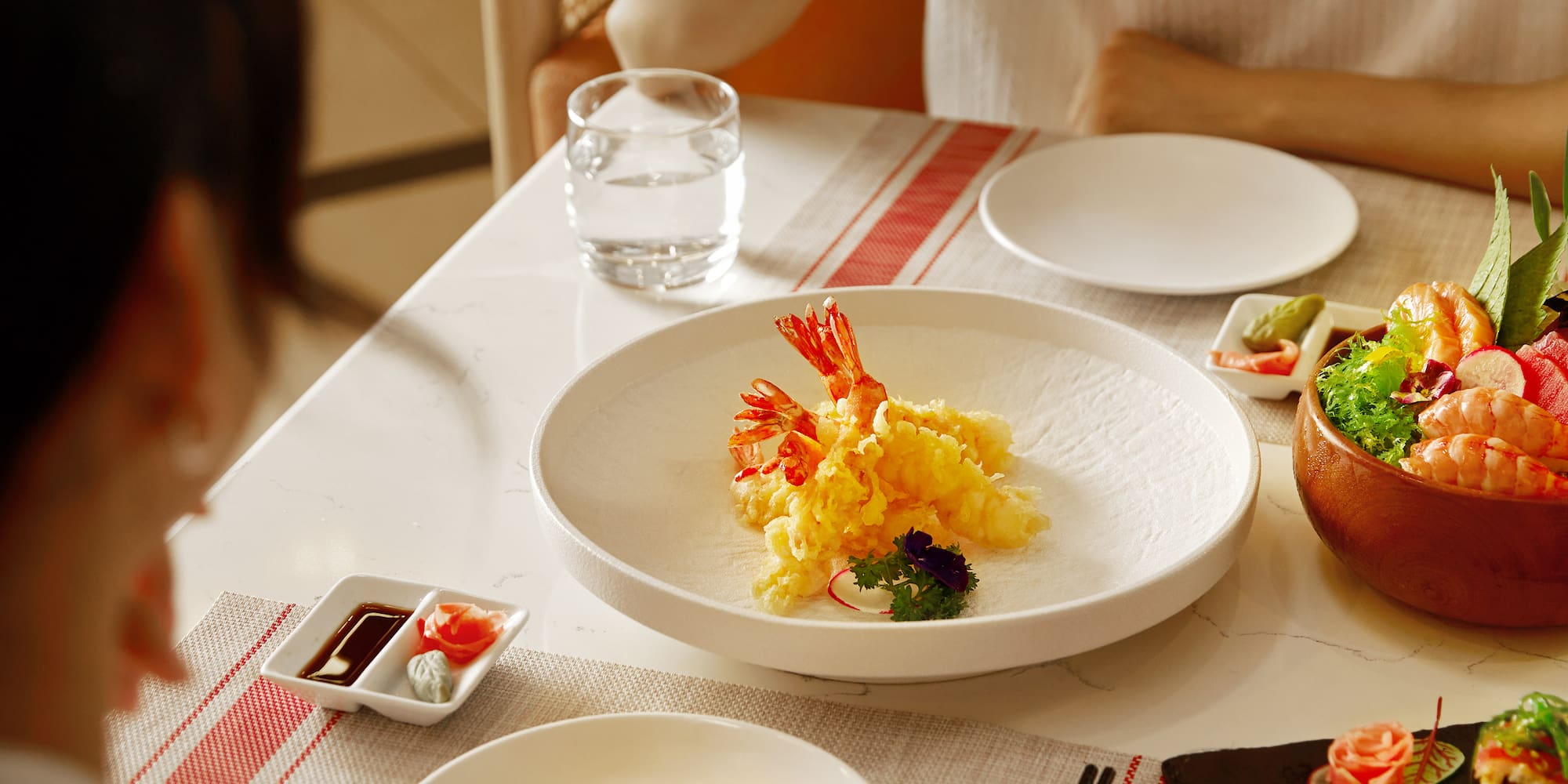 a group of people eating sushi at a table