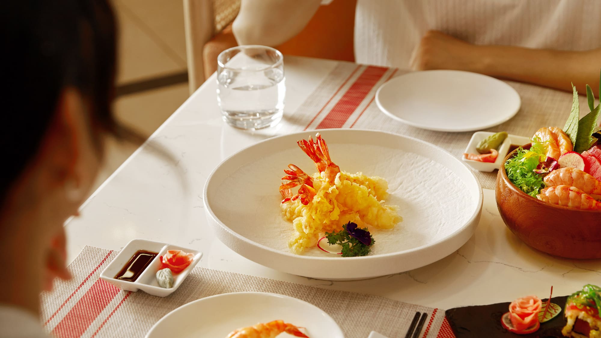 a group of people eating sushi at a table
