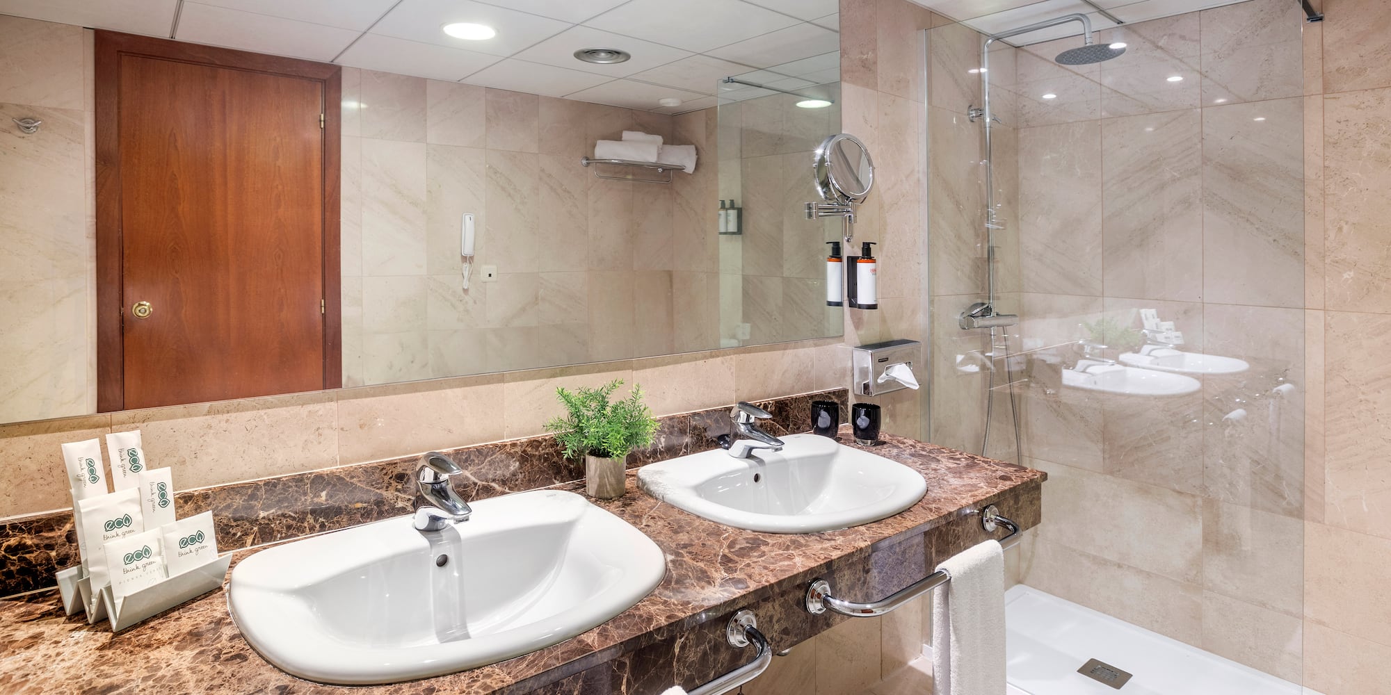 a bathroom with marble countertop sinks and shower